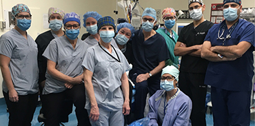 group of physicians dressed in scrubs in the operating room