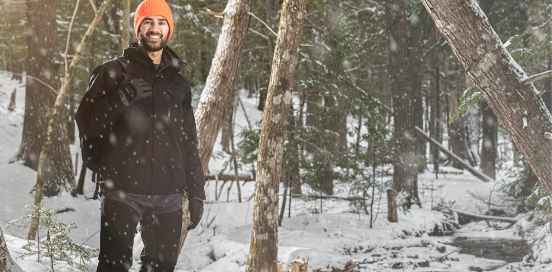 Dr. Simran Ohson standing in the forest with snow falling