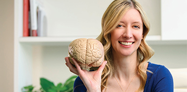 Dr. Kerrie Schoffer holding a model of a brain