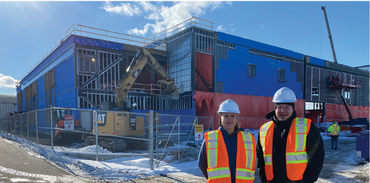 Dr. Jennifer Lange, clinical co-lead, and Mickey Daye, clinical director with the CBRM Health Care Redevelopment Project, on the construction site of the New Waterford Community Hub project. Both are wearing orange and yellow safety vests and white hard hats.