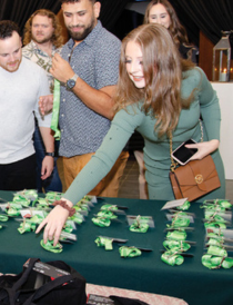 medical students picking up name badges from a table with a green tablecloth