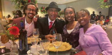 persons of colour sitting at a dinner table during an event