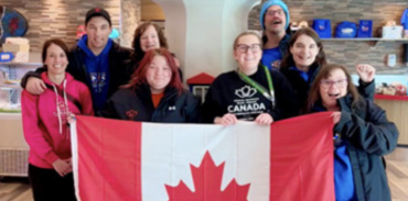 group of Special Olympics athletes holding a Canadian flag