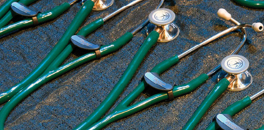 forest green stethoscopes on a black table