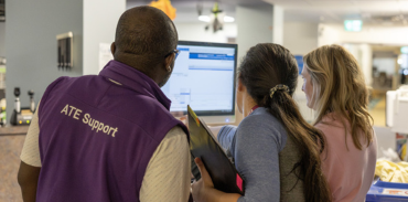 2 females and 1 male looking at a computer screen in a healthcare environment