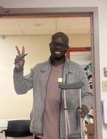 medical student Korede Akindoju holding crutches in a hospital room doorway