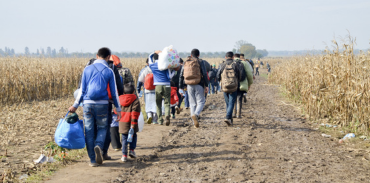 refugees walking along a dirt path