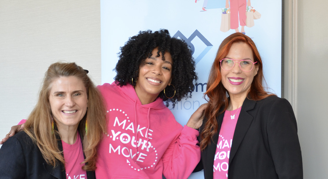 Three women standing in front of a Healthy Tomorrow Foundation banner