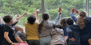 group of children looking out a window