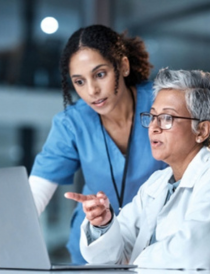 two female healthcare workers looking at a computer screen
