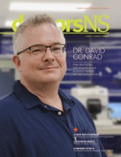 Dr. David Conrad wearing scrub gown and cap on the cover of the October 2022 edition of the doctorsNS magazine