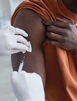 close up of adult African American receiving a vaccination