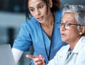 two female healthcare workers looking at a computer screen