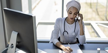 Muslim female physician speaking on the phone
