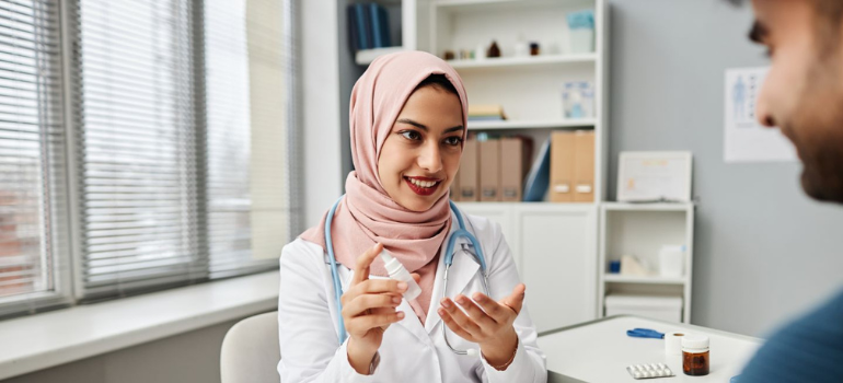 female physician wearing a hijab and counselling a male patient