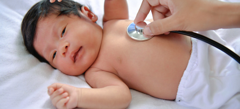 A baby with a provider listening to it's heart.