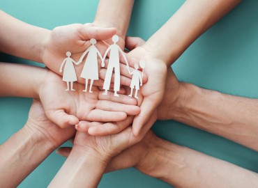 image of many hands, upright, holding a cut out family