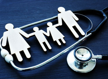 paper cut out family with a stethascope surrounding them