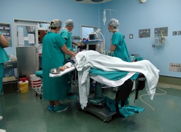 surgery room image. patient on bed with physicians surrounding patient