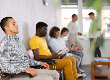 people sit and stand in a waiting room