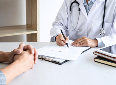 physician sitting at a desk writing on papers