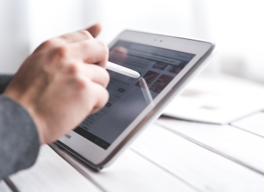 image of left hand holding a tablet and write hand selecting something on the screen with a stylus