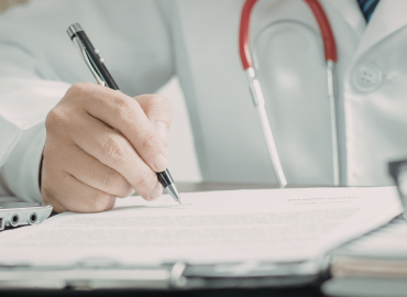 physican writing on notepad