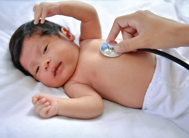 A baby with a provider listening to it's heart.