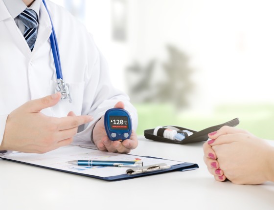 a physician sits across from a patient at a table