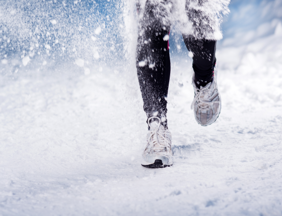 a pair of legs from knee down running in the snow