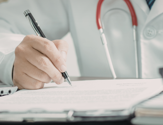 physican writing on notepad