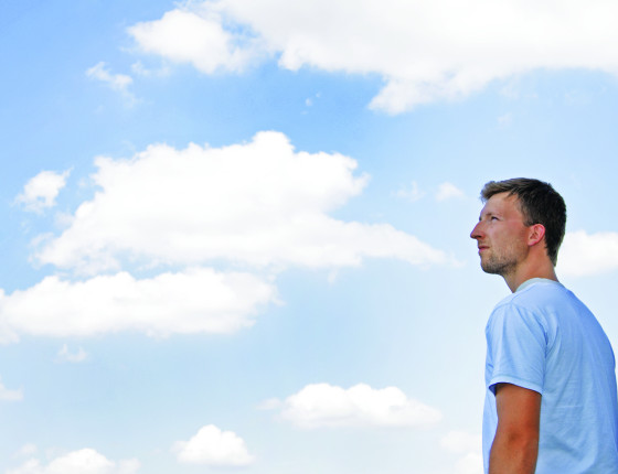 Man in front of a cloudy sky
