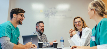 Doctors gathered around meeting table